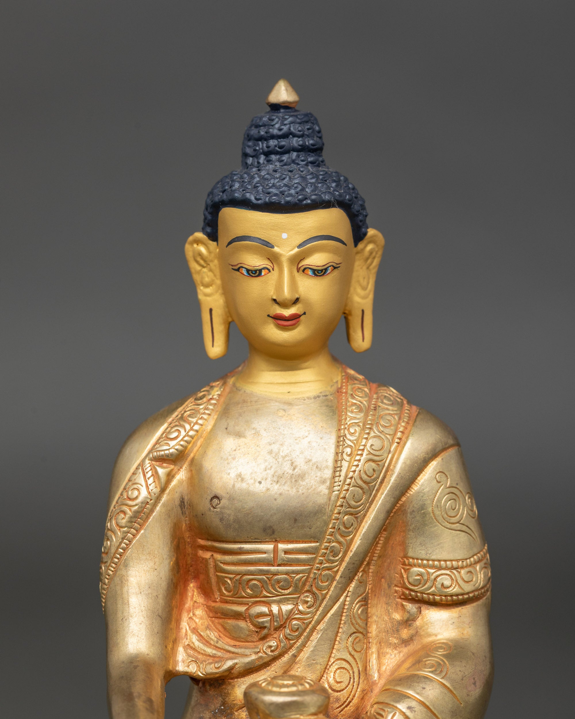 Close-up of Buddha Shakyamuni meditation statue showing gold fire-gilded details