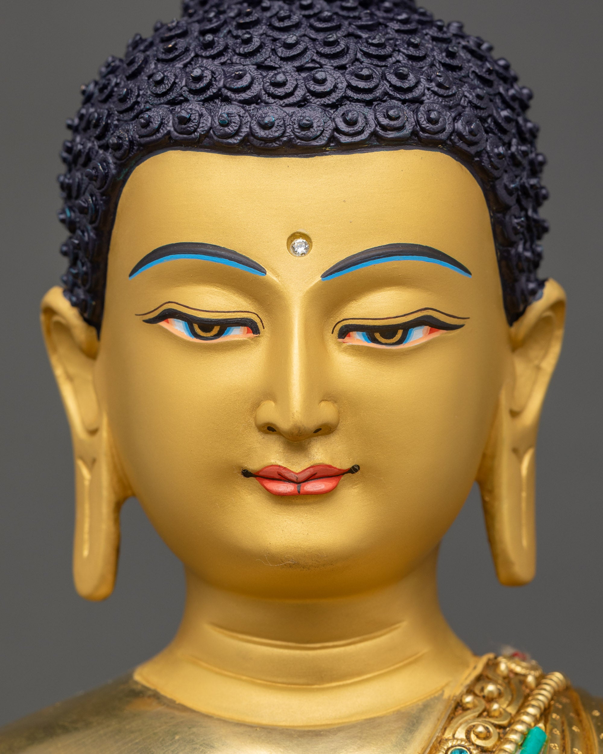 Shakyamuni Buddha statue face with deep blue eyes and long sculpted lashes