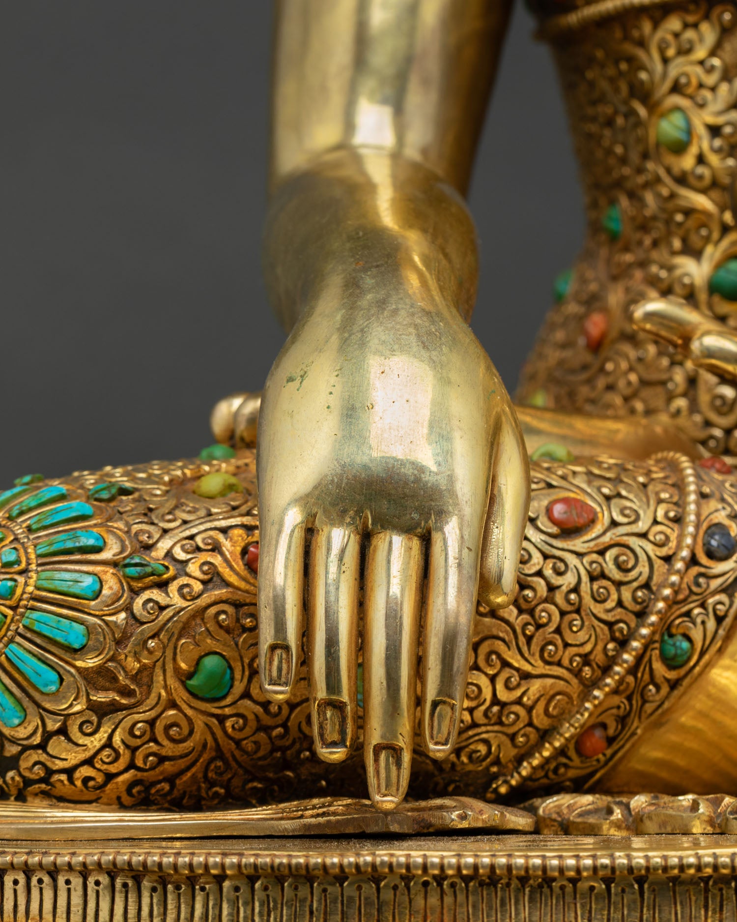 close-up-of-buddha-statues-hand-resting-on-turquoise-inlaid-lotus-base