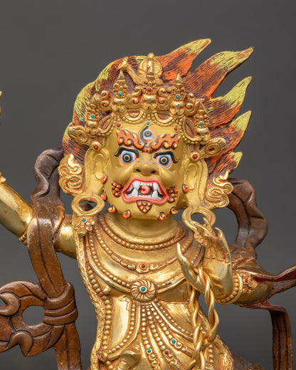 Close-up of Chana Dorje protector statue showing intricate gold-painted face and vajra detail