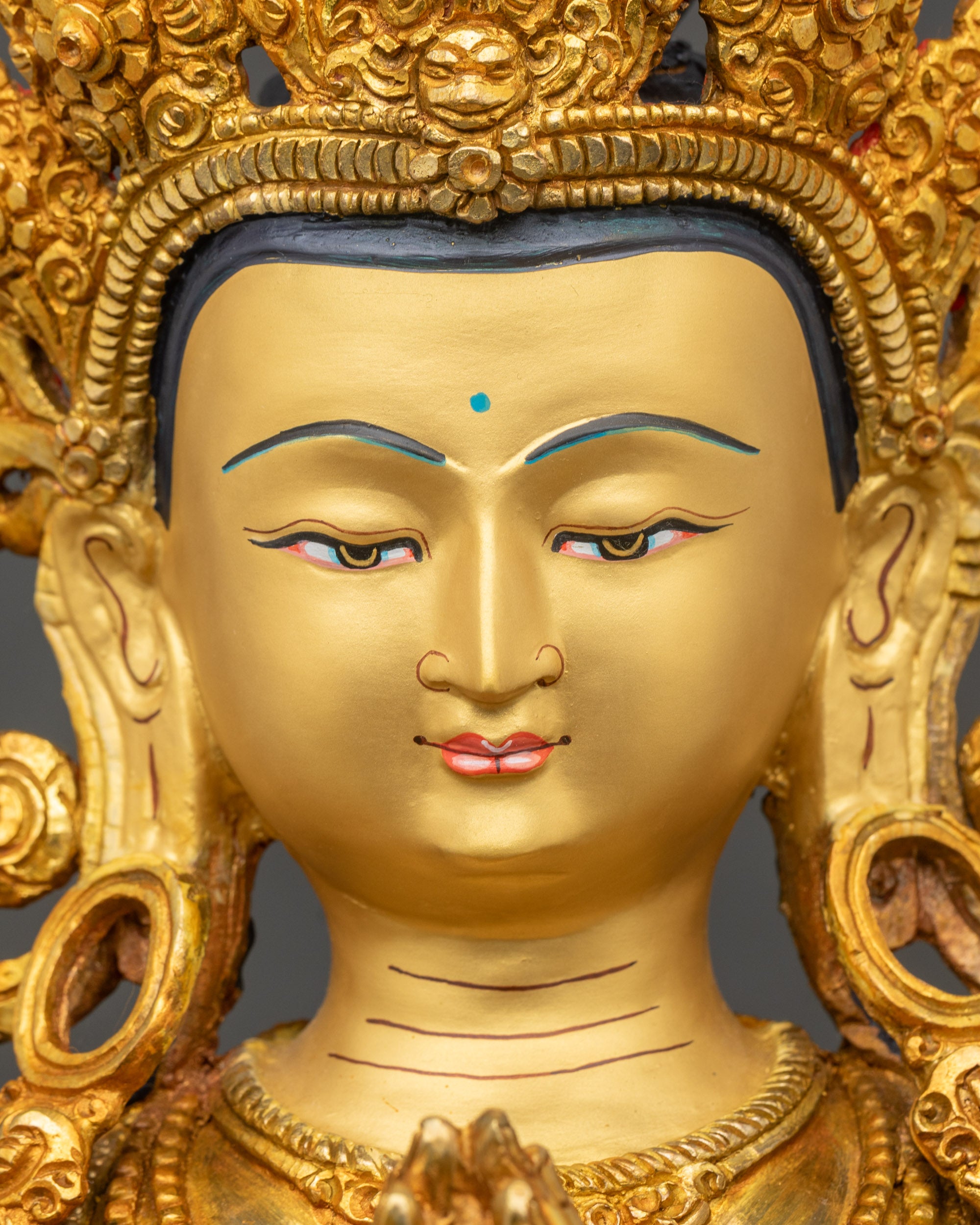 Close-up of Chenrezig Avalokiteshvara gold-gilded face, Himalayan Buddhist compassion deity statue