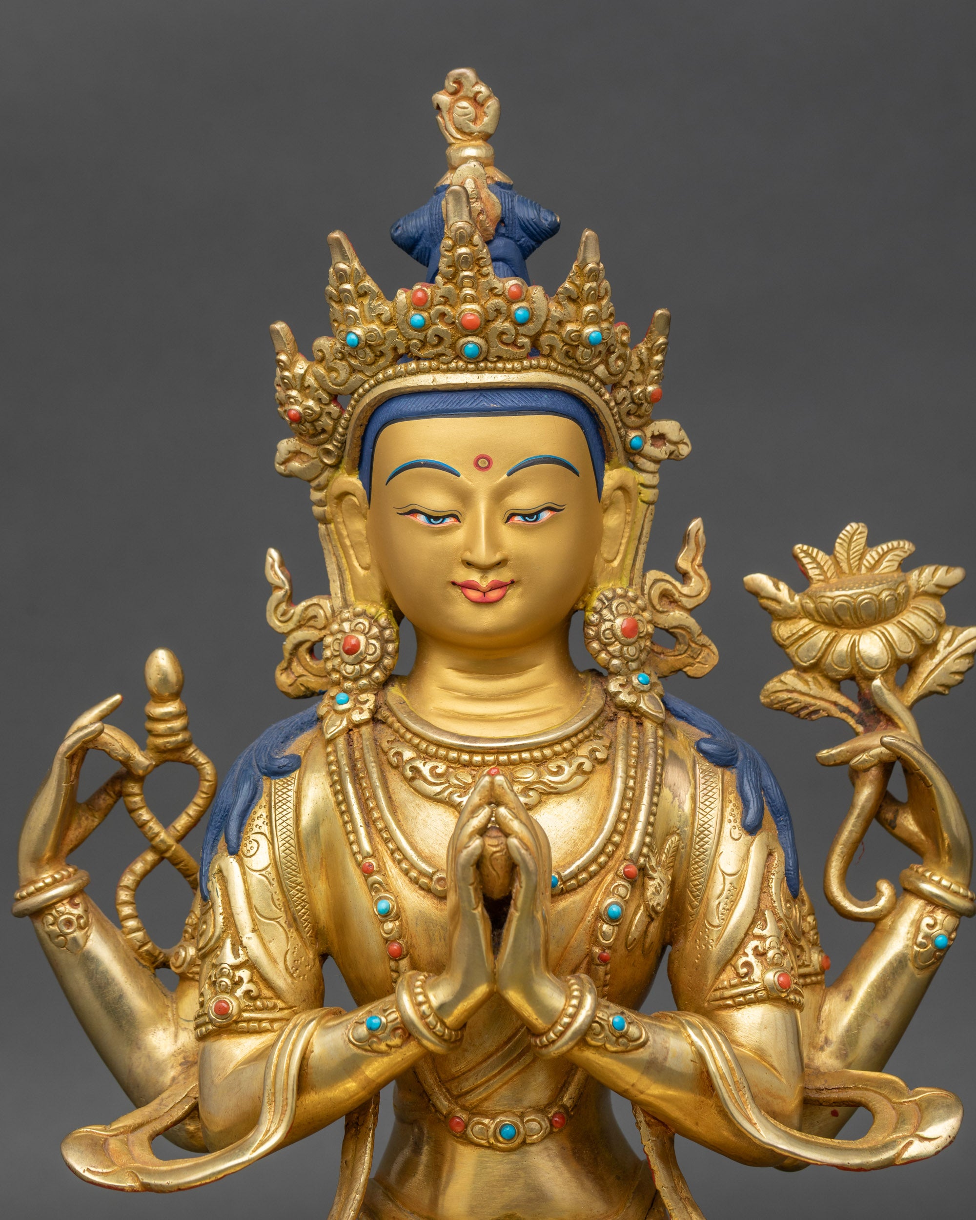 Close-up of Chenrezig Bodhisattva face, gold-painted features and intricate craftsmanship