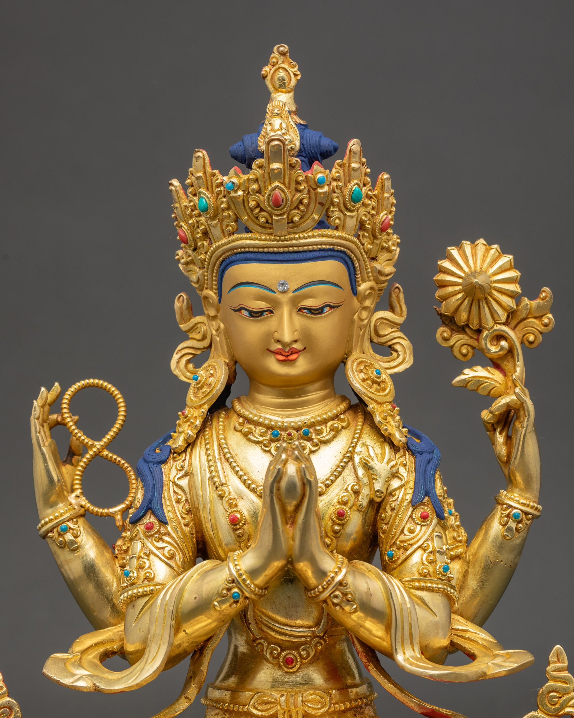 Close-up of Chenrezig Bodhisattva face with 24K gold paint, radiant spiritual detail
