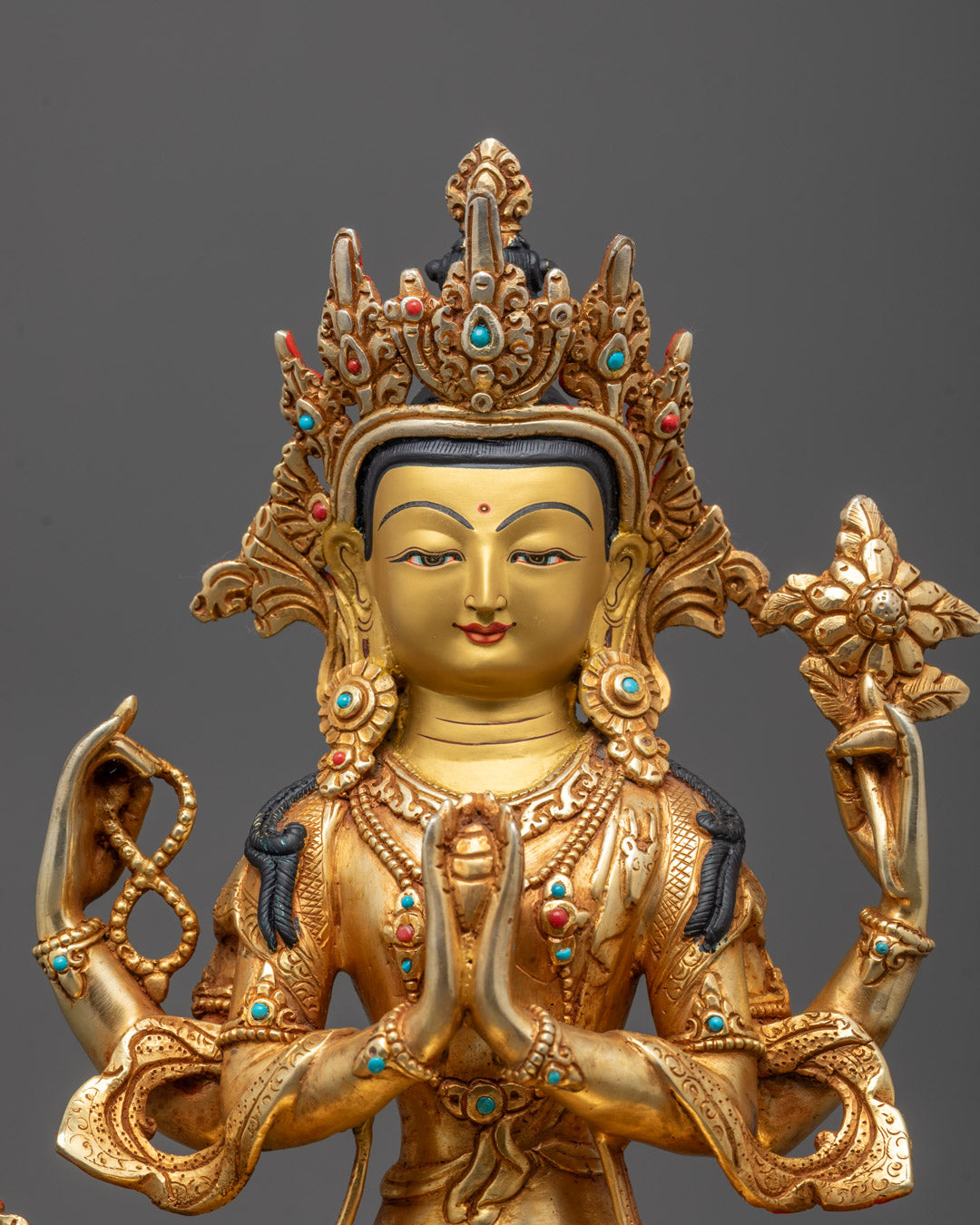 Close-up of Chenrezig Statue showing four arms holding lotus flower