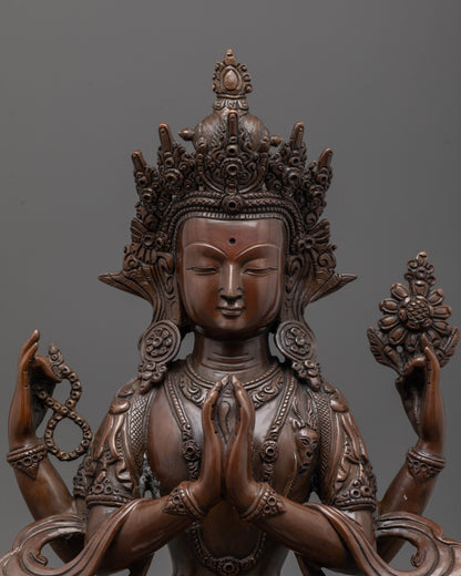 Close-up of Chenrezig statue's serene face and deer symbol beside heart, oxidized finish
