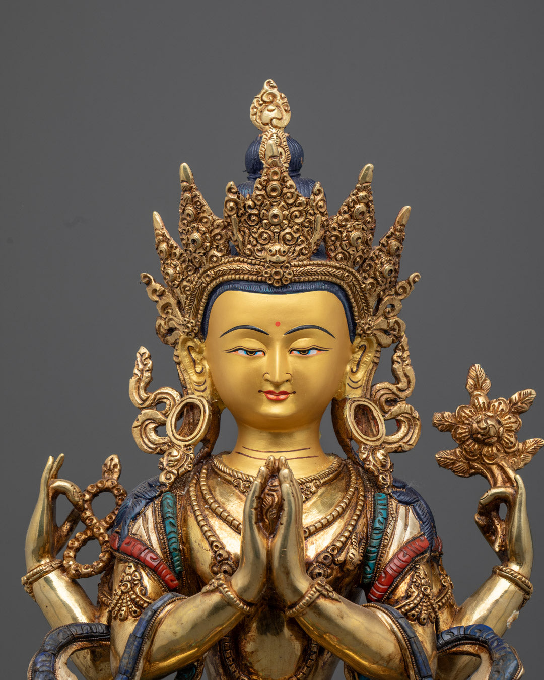 Chenrezig statue’s serene face with detailed multi-colored acrylic painting and intricate craftsmanship from Nepal.