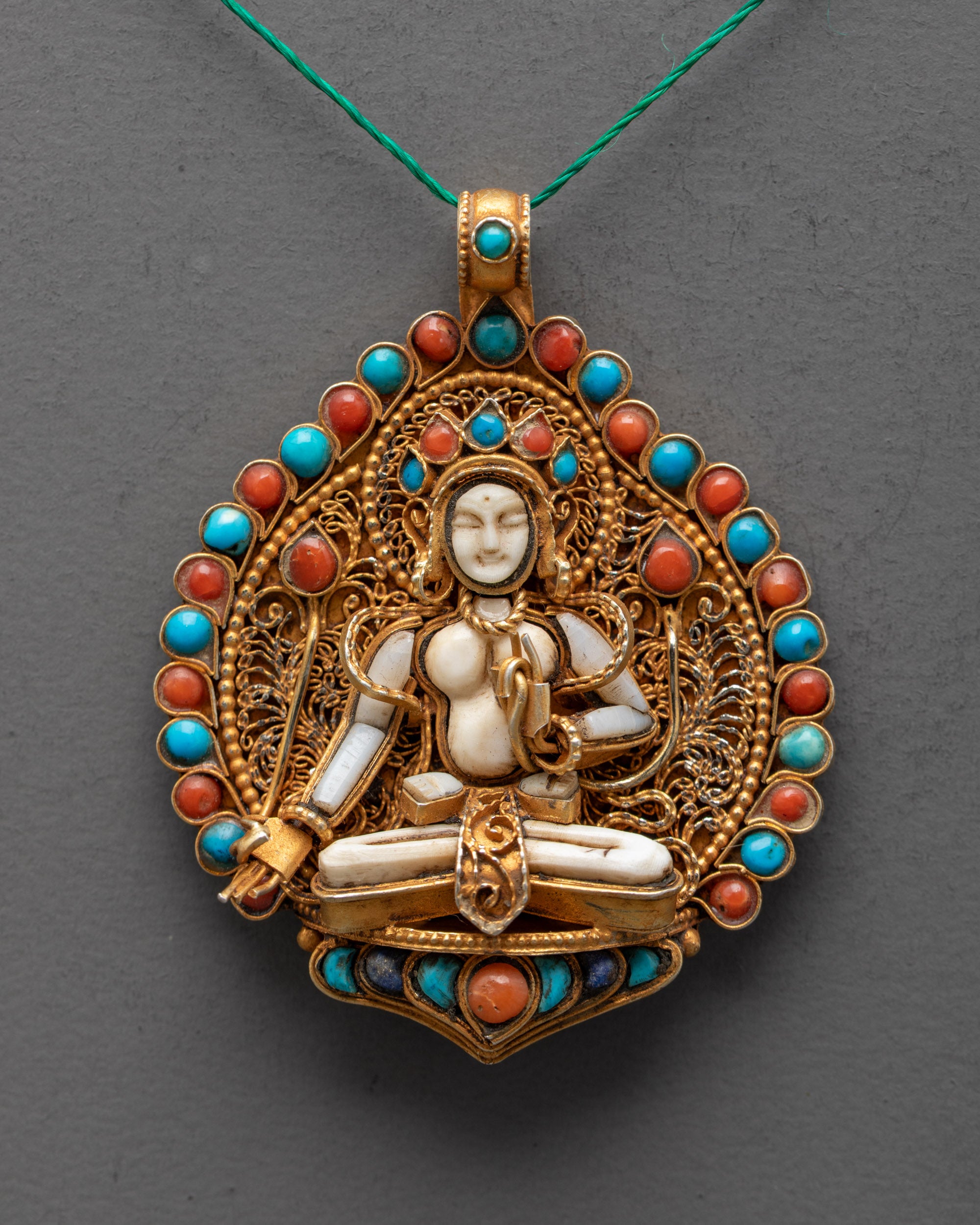 Close-up of Crystal White Tara locket showcasing detailed gold-gilded filigree and semi-precious stones – Tibetan healing and protection talisman.