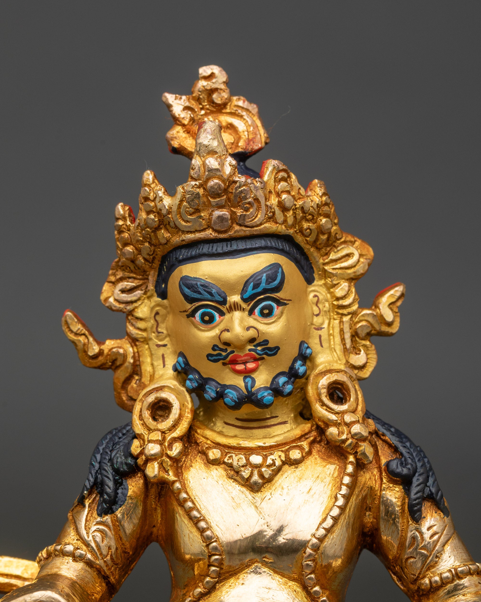 Close-up of Dzambhala Statue face with 24k gold, intricate Newari artisan details