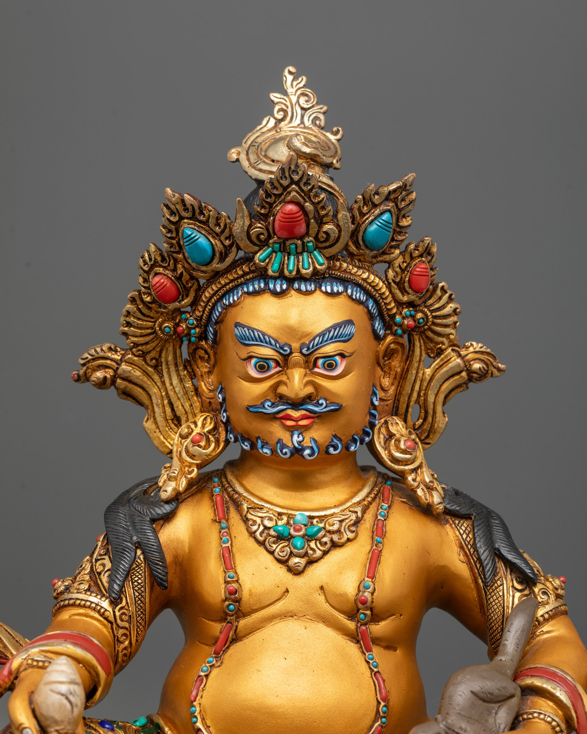 Close-up of Dzambhala Statue showing intricate carvings, citron fruit, and mongoose details
