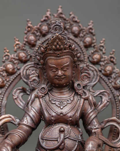 Close-up of Dzambhala face and right hand holding citron fruit, jewel, or jewel-spitting trident