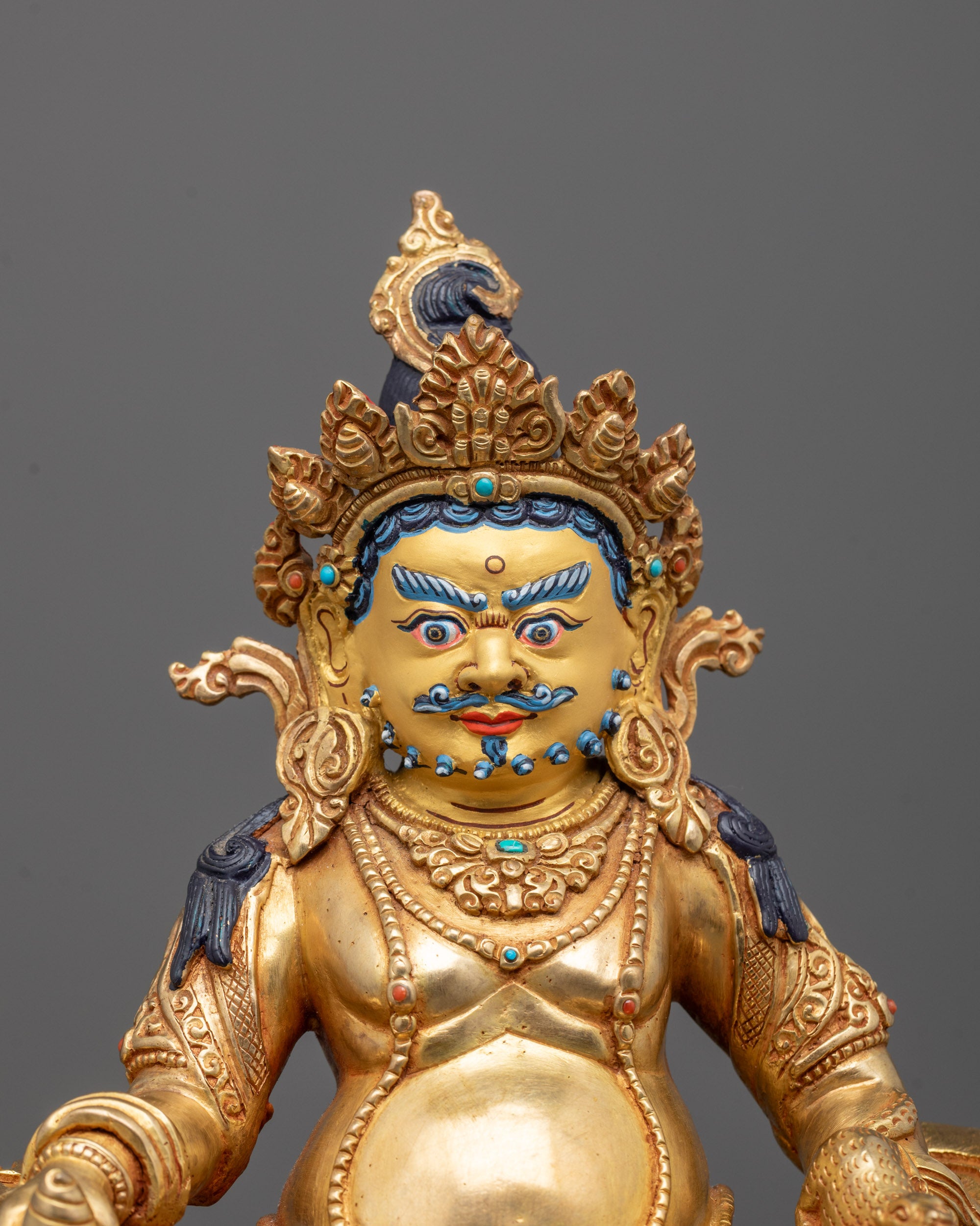 Close-up of Dzambhala's wrathful expression with jewel-spitting mongoose