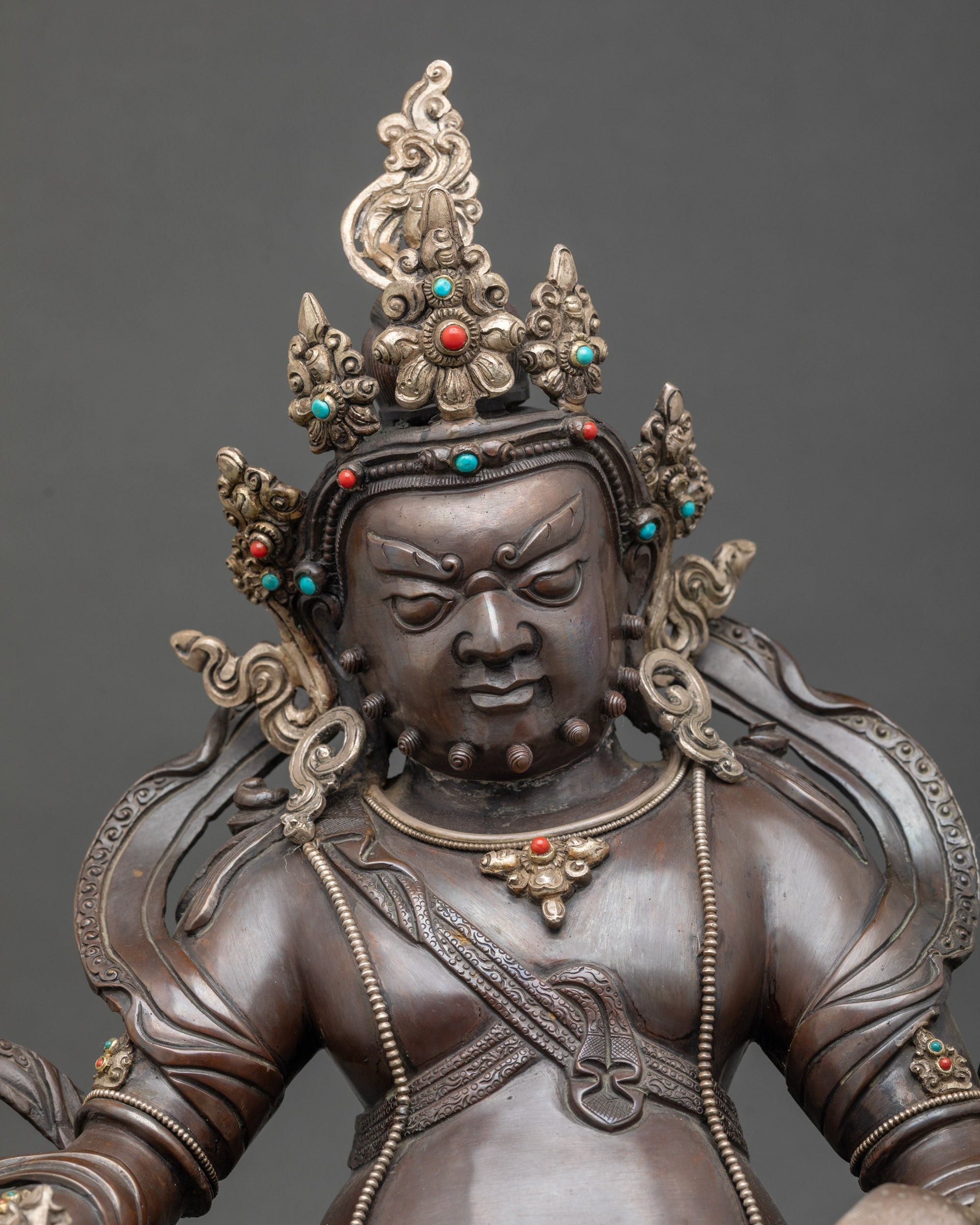 Close-up of Dzambhala statue holding citron fruits and jewels, handcrafted by Newari artisan from Patan