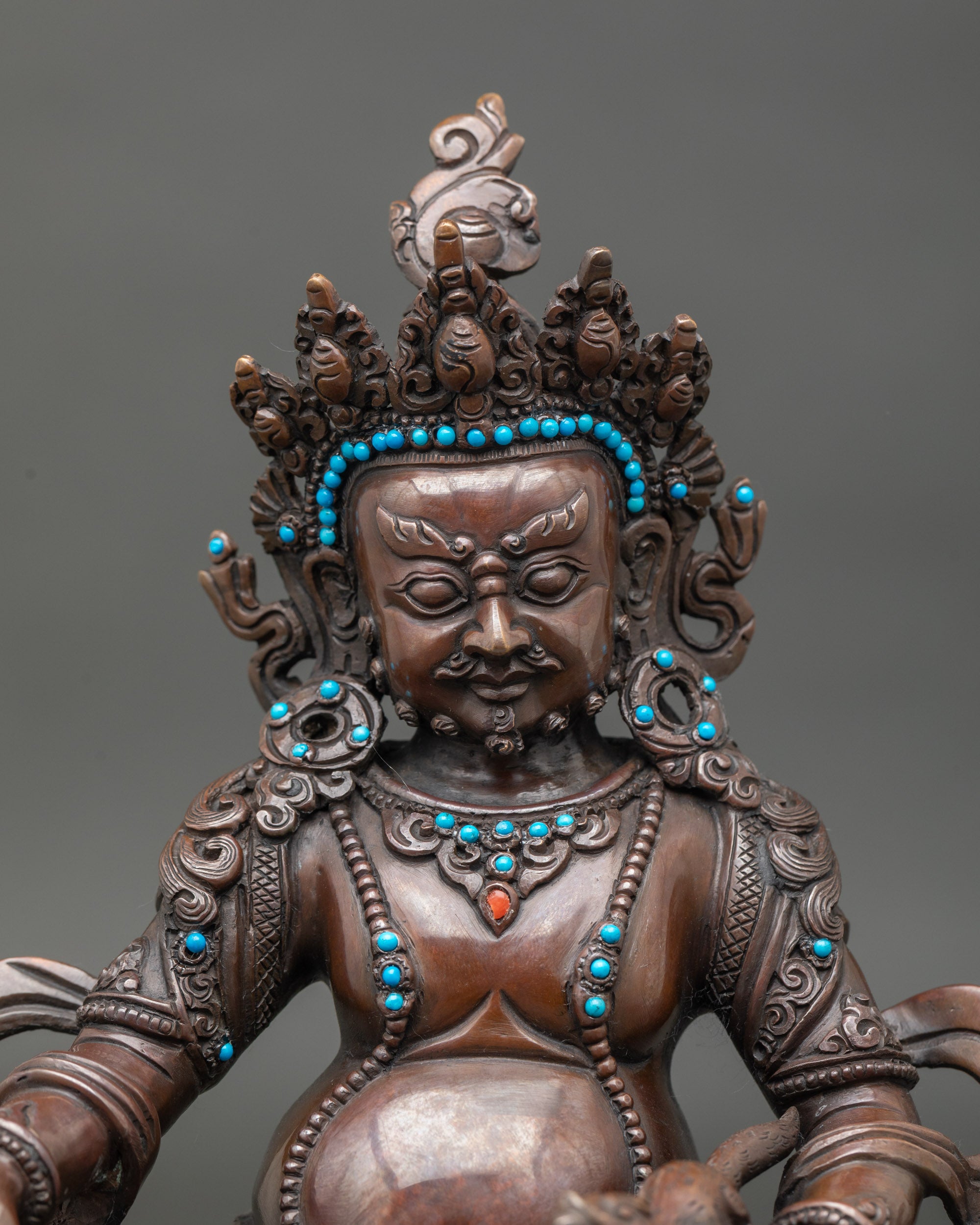 Close-up of Dzambhala statue showing intricate details and Tibetan Buddhist craftsmanship