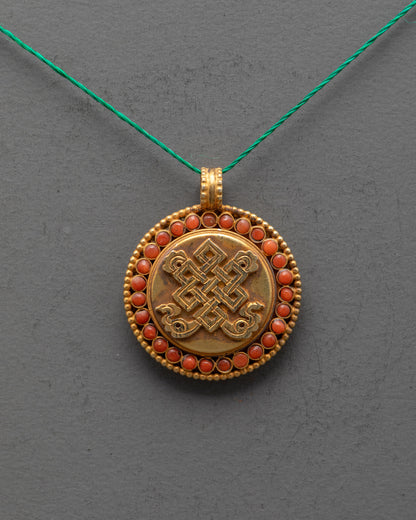 Close-up of Endless Knot Locket showing detailed carving and coral gemstone inlay