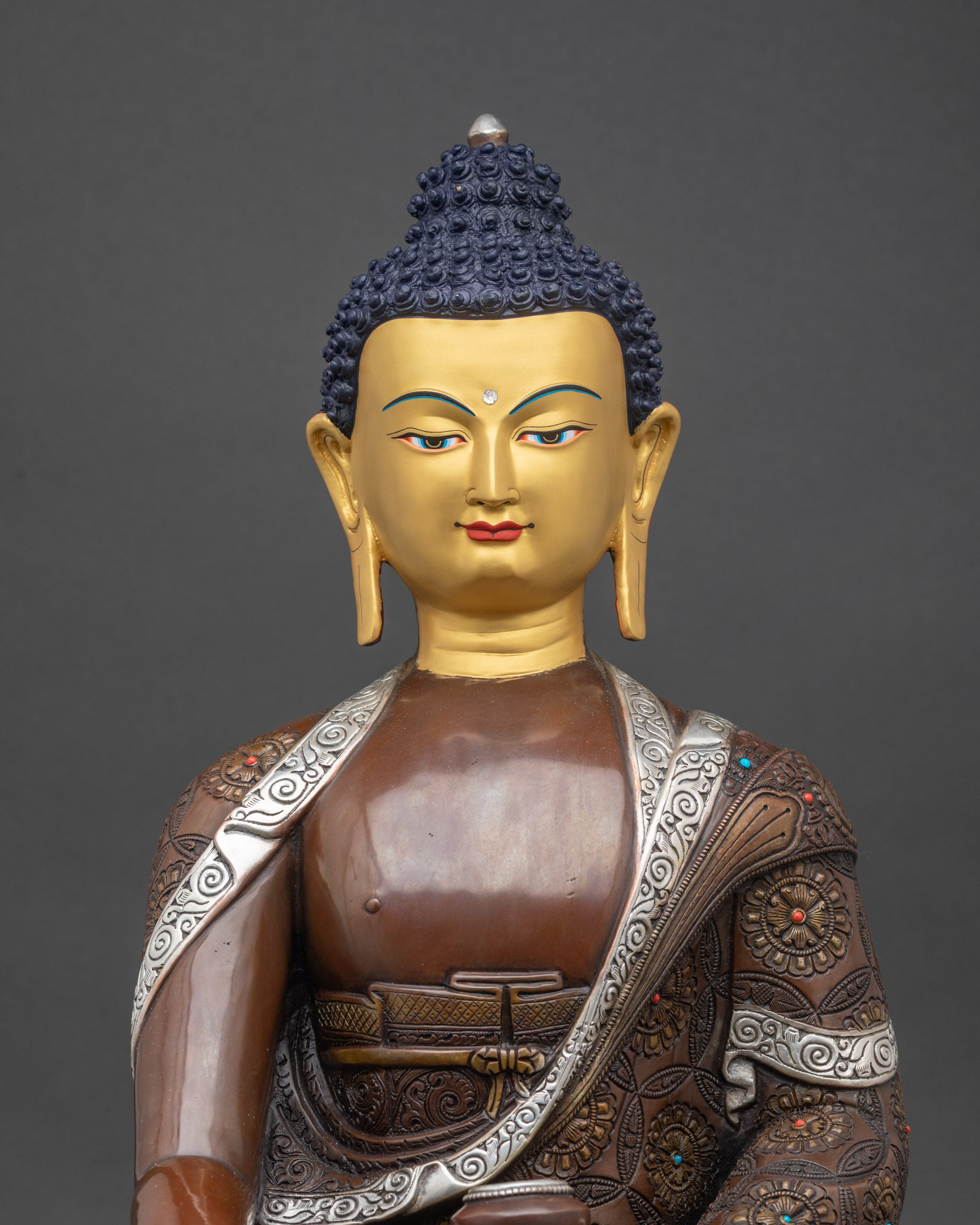 Close-up of Enlightened Shakyamuni Buddha face with gold-painted features and serene expression
