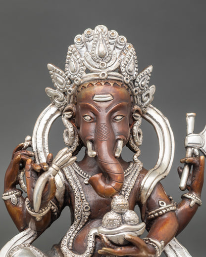 Close-up of Ganesh statue showing intricate silver-plated details and sacred symbolism
