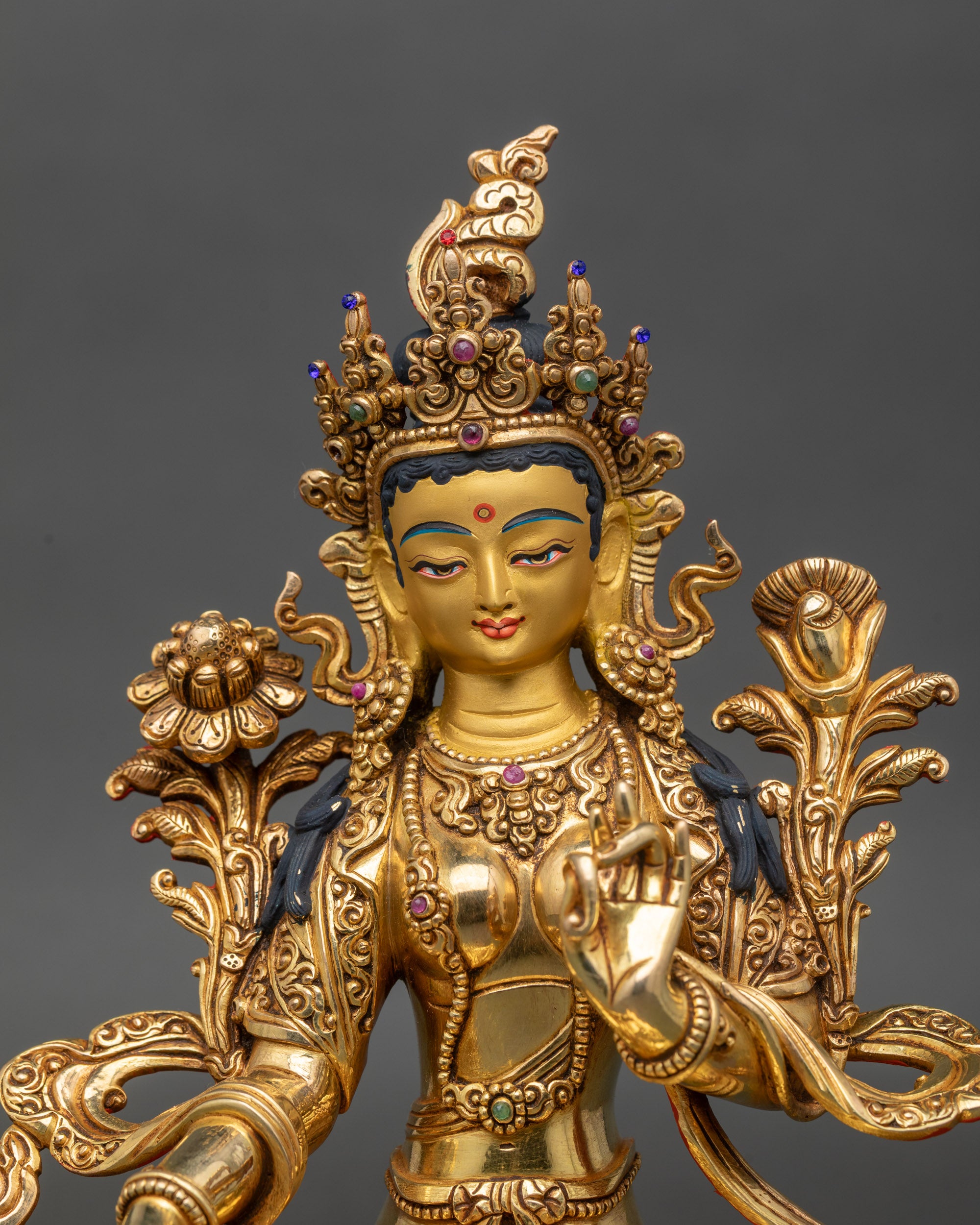 Close-up of Green Tara Bodhisattva face, serene expression, fire-gilded