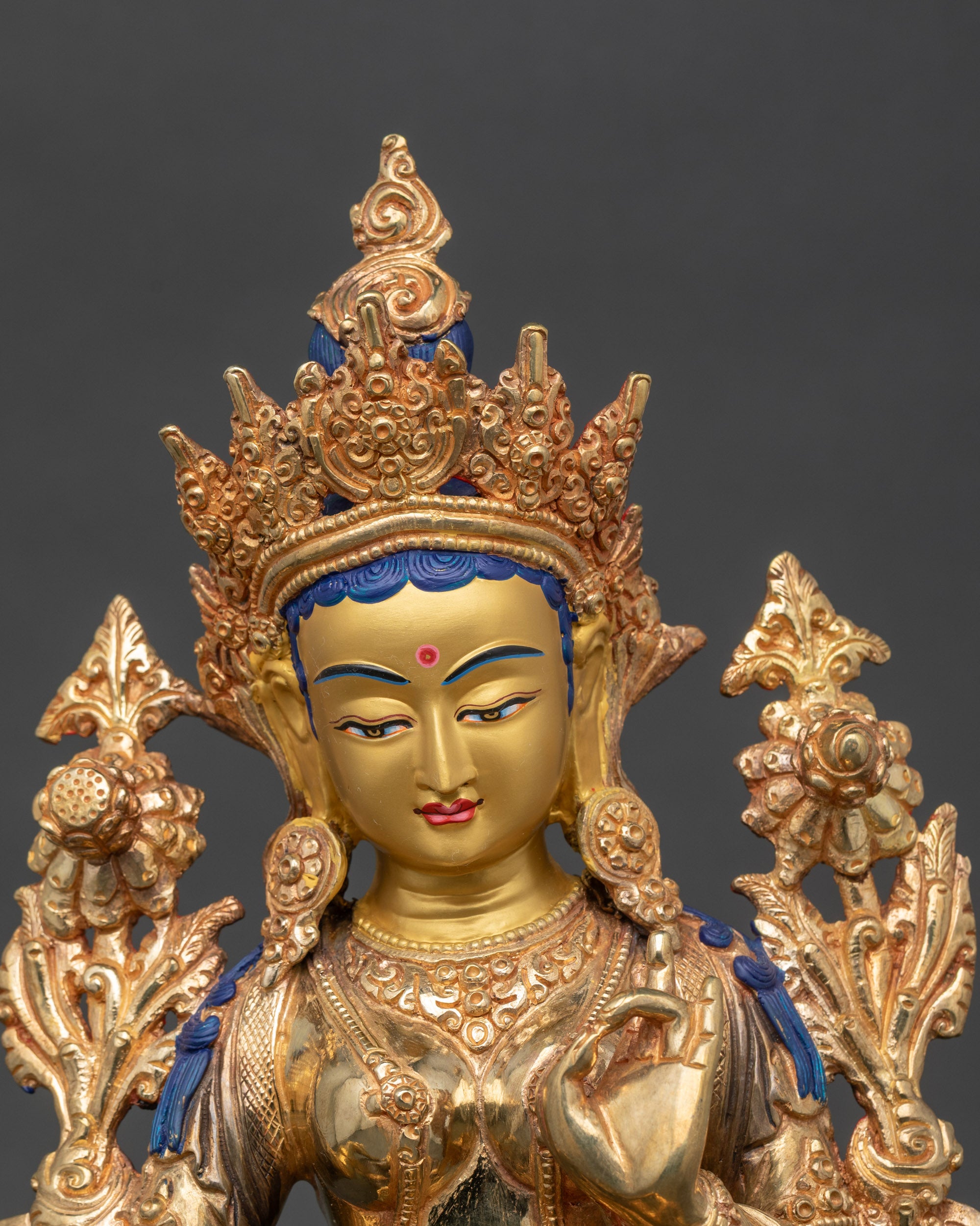Close-up of Green Tara Bodhisattva face with gold fire-gilded details on lotus pedestal