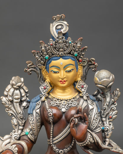 Close-up of Green Tara Bodhisattva holding utpala flowers, adorned with semi-precious stones