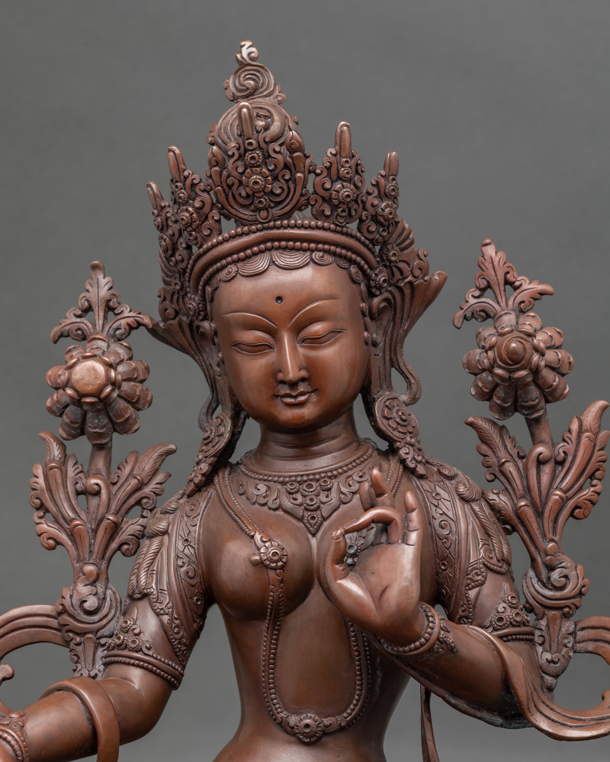 Close-up of Green Tara face showing serene expression and gold-painted details