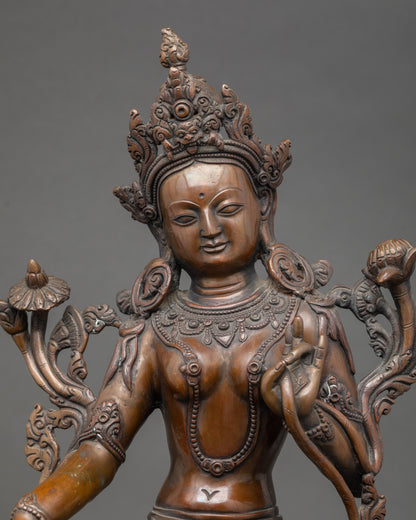Close-up of Green Tara face showing serene expression and gold detailing