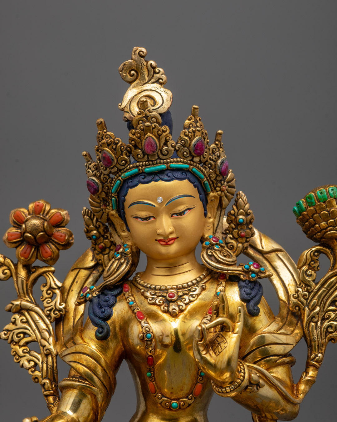 Close-up of Green Tara face with 24k gold gilded finish and copper base