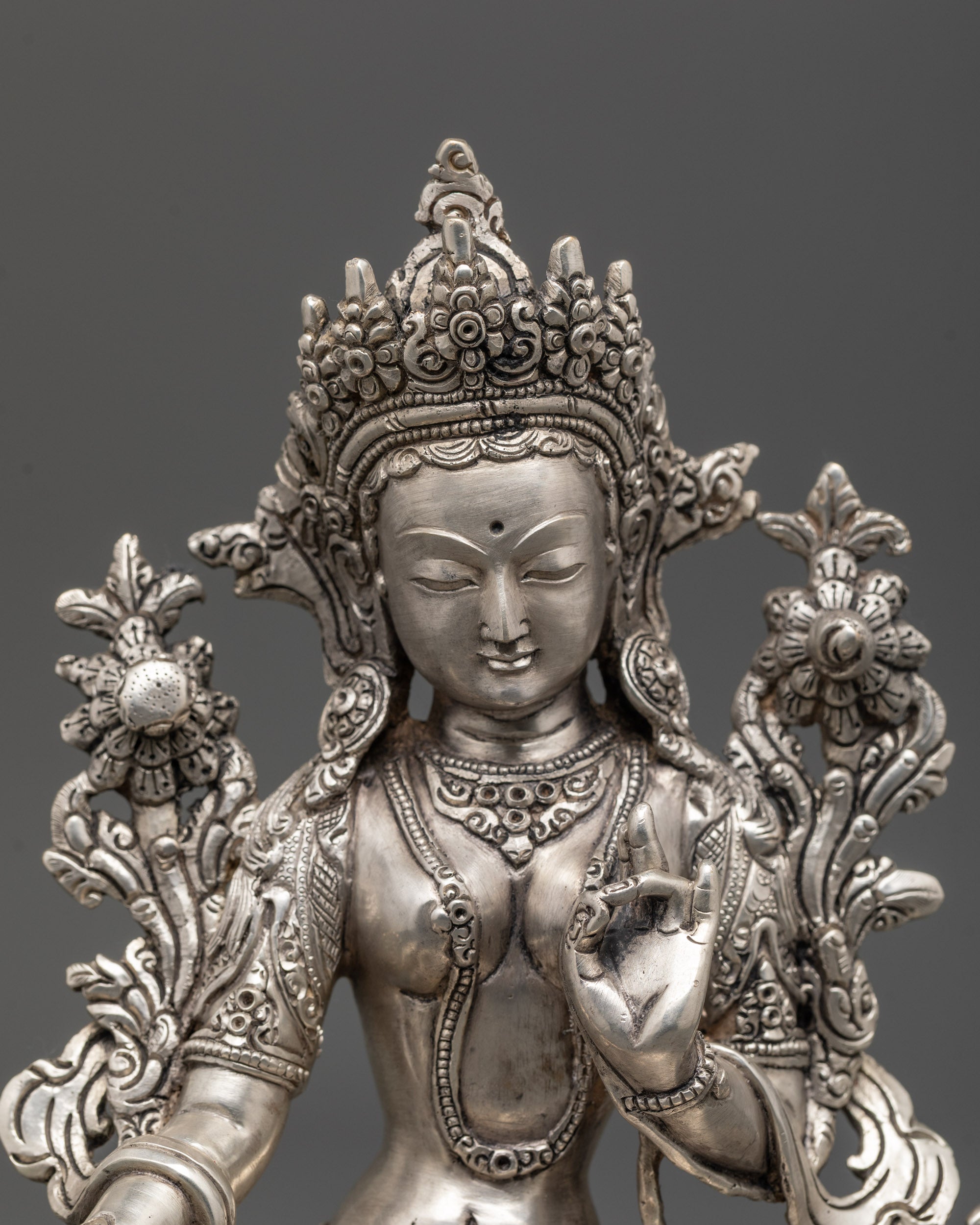 Close-up of Green Tara face with intricate silver-plated detailing