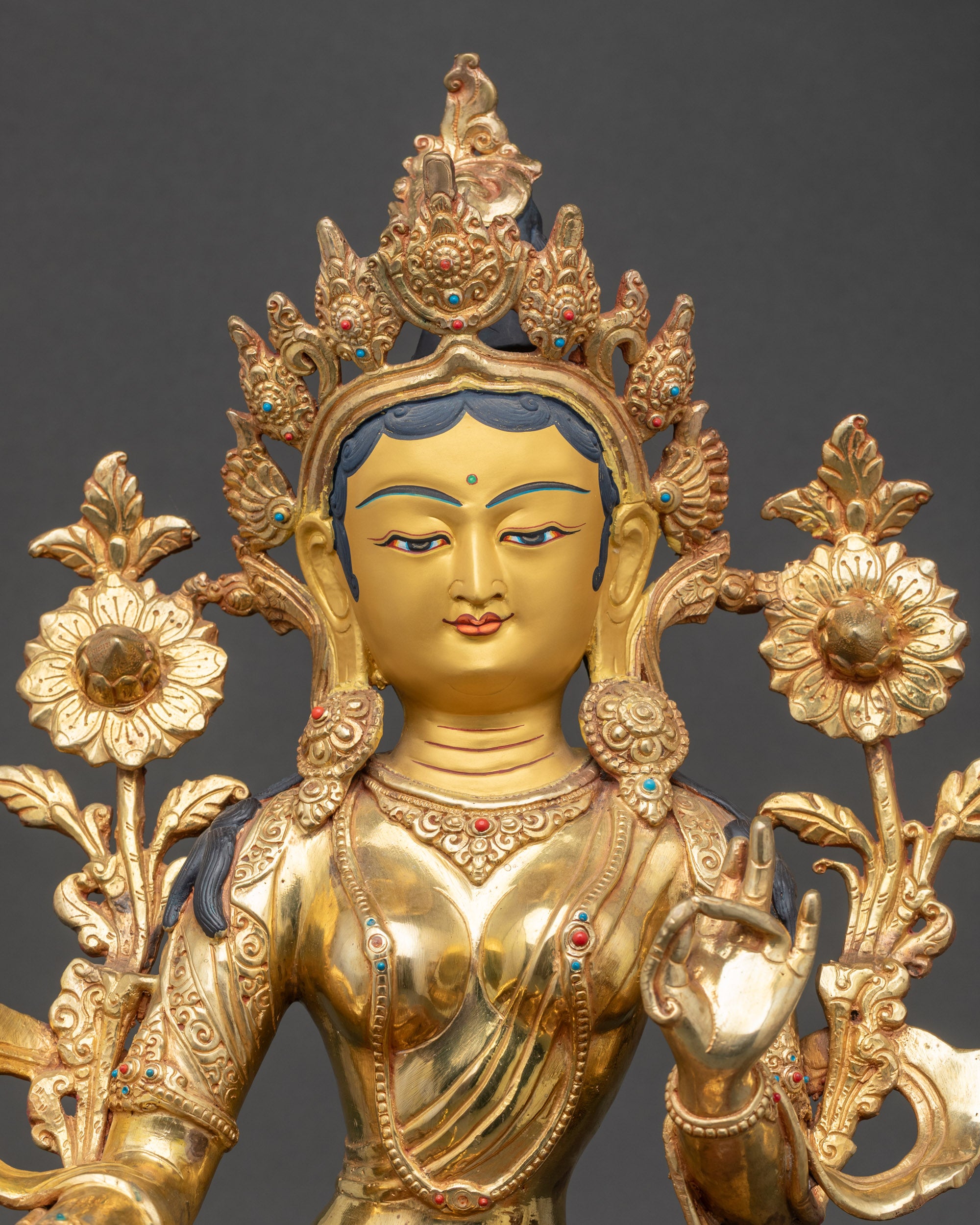 Close-up of Green Tara gold-painted face and detailed Himalayan craftsmanship carvings