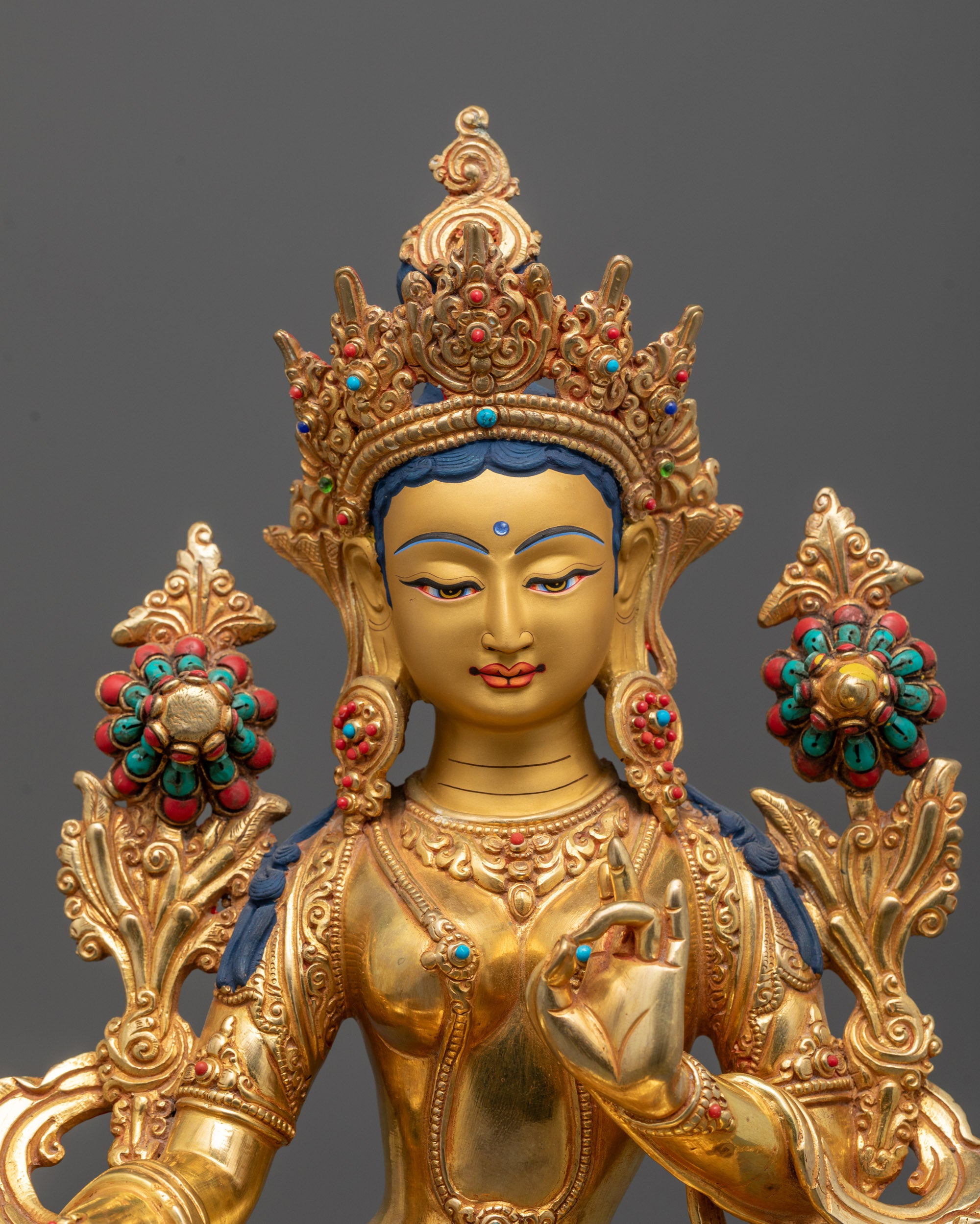 Close-up of Green Tara’s face with polished 24k gold details, showcasing peaceful expression
