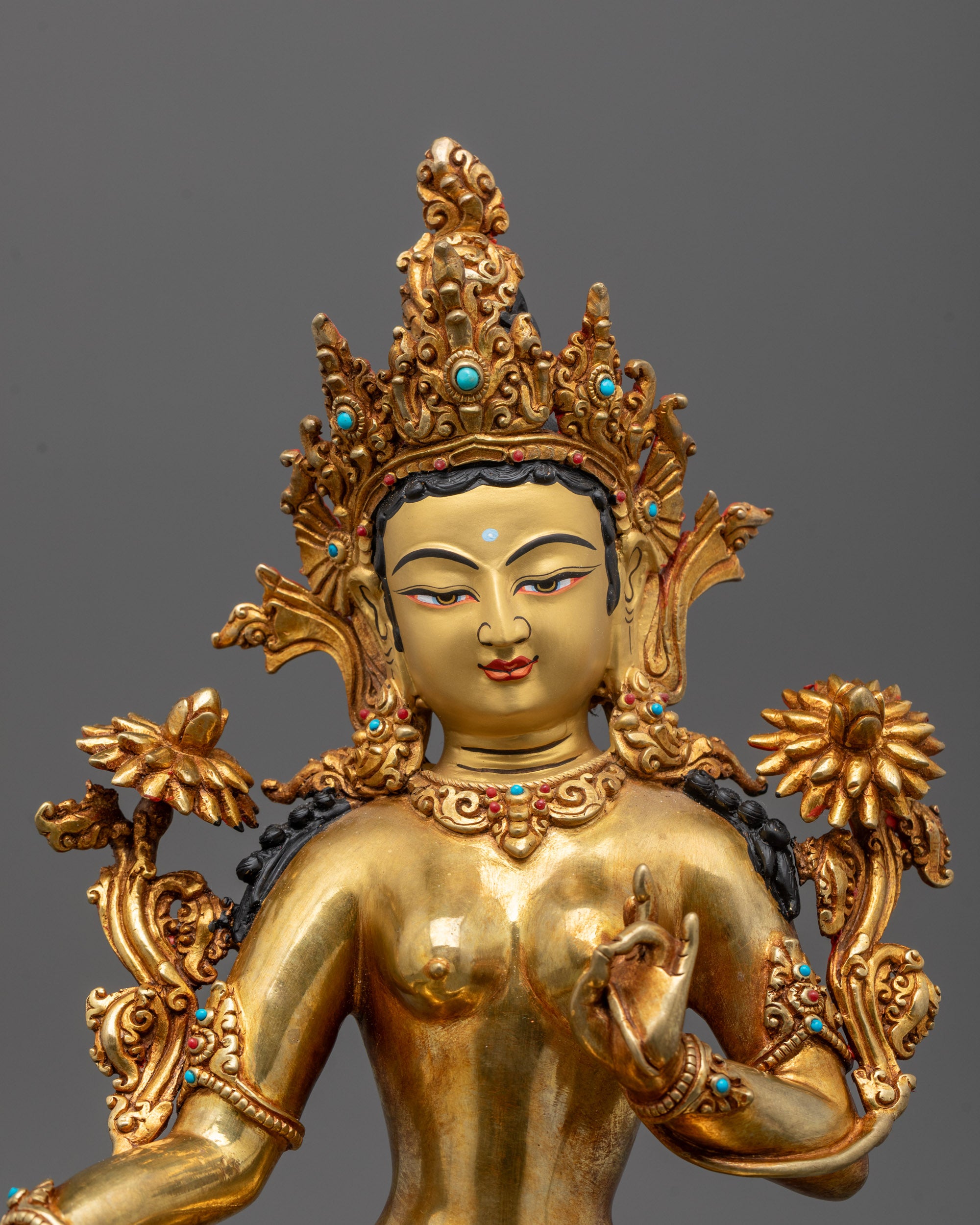 Close-up of Green Tara’s face with pure gold gilded finish and intricate hand-painted