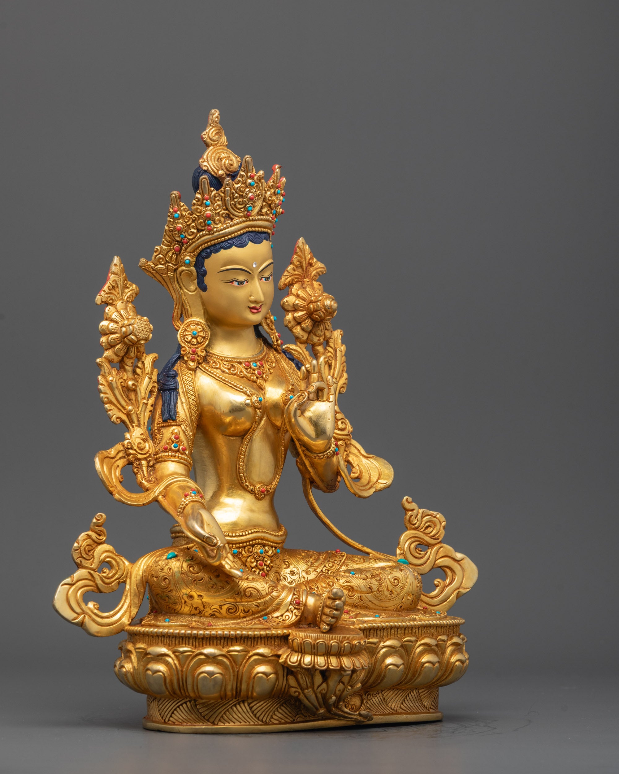 Close-up of Green Tara’s face with serene expression, adorned with fire-gilded gold