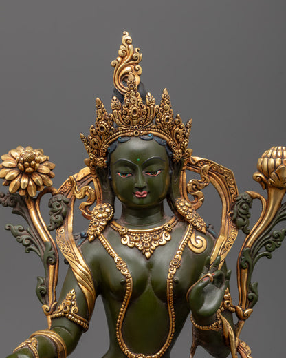 Close-up of Green Tara’s gold-gilded face with delicate features and varada mudra