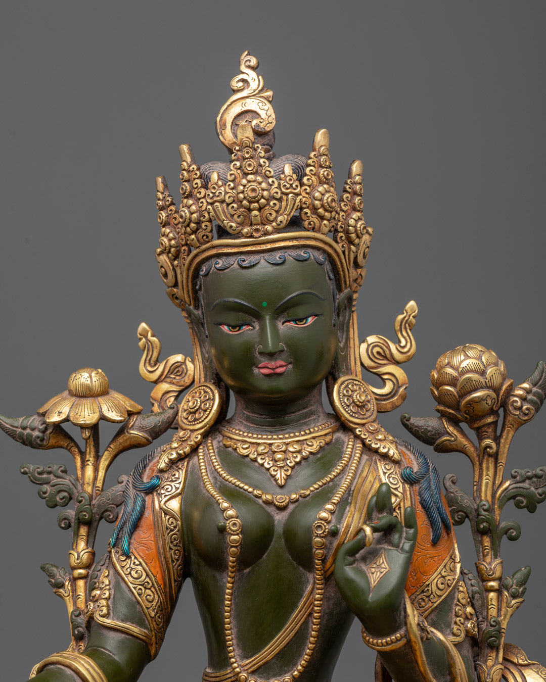 Close-up of Green Tara's serene Colored face and jeweled crown