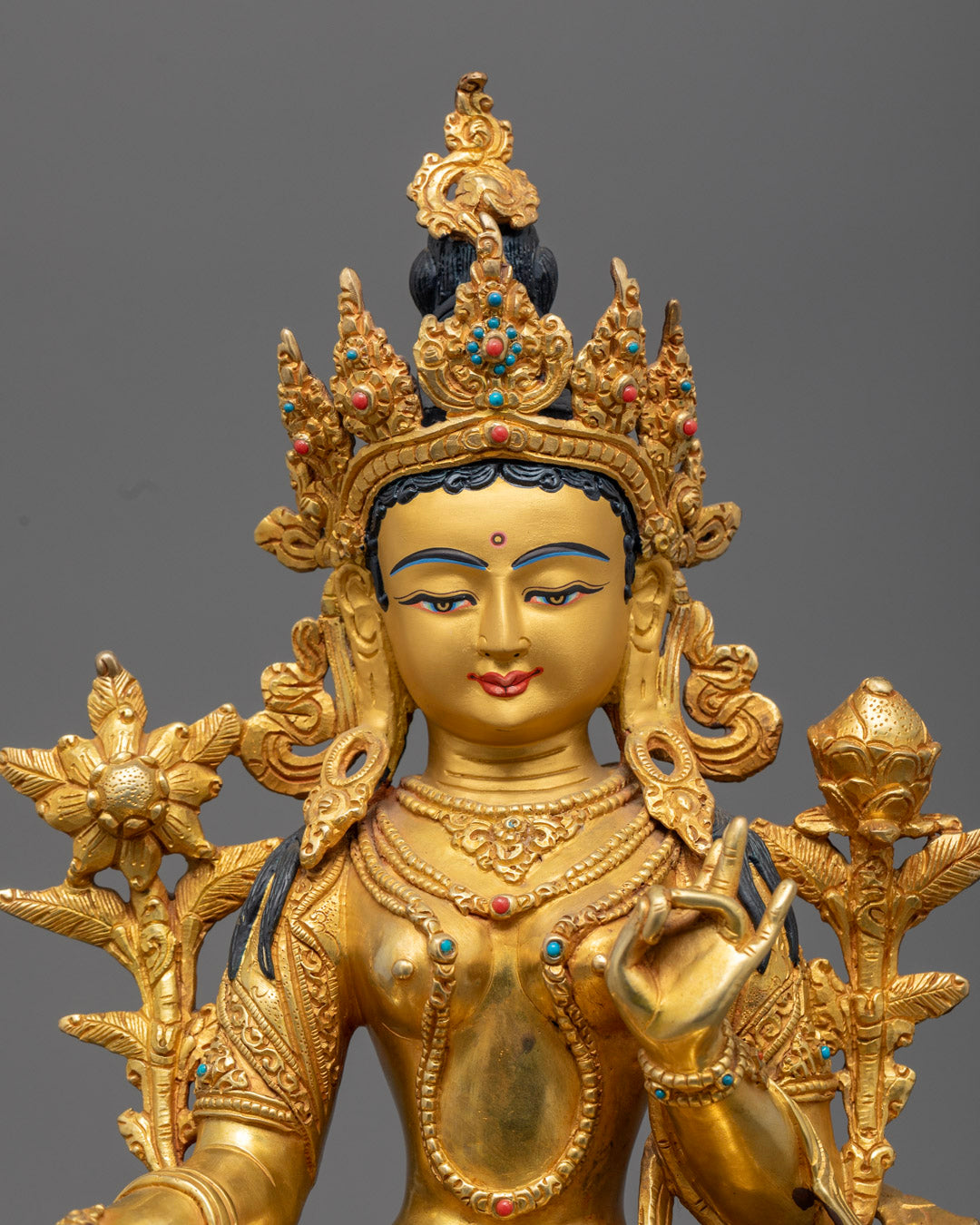 Close-up of Green Tara's serene expression and intricate halo, showcasing detailed craftsmanship.