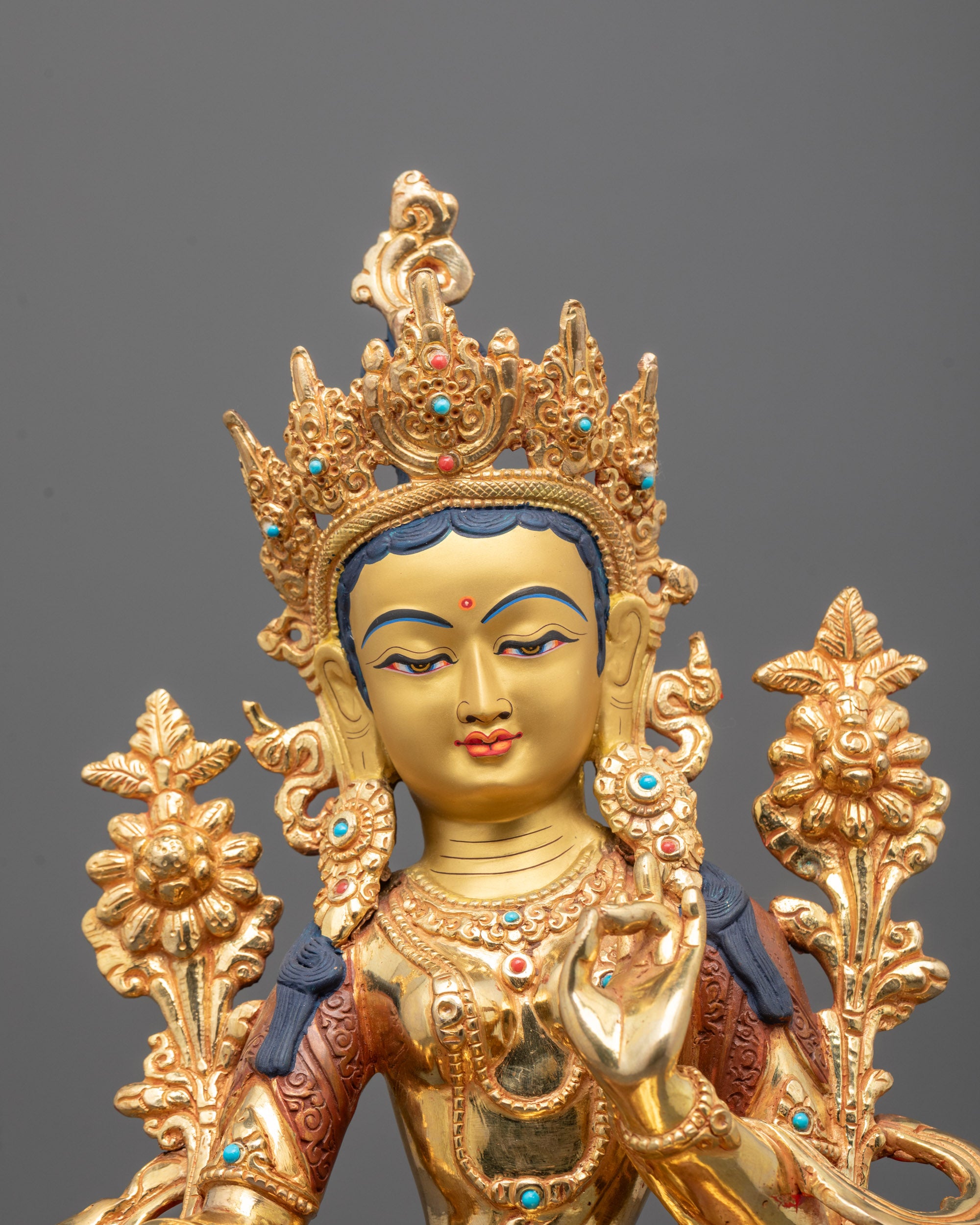 Close-up of Green Tara’s serene face and detailed semi-precious stone adornments