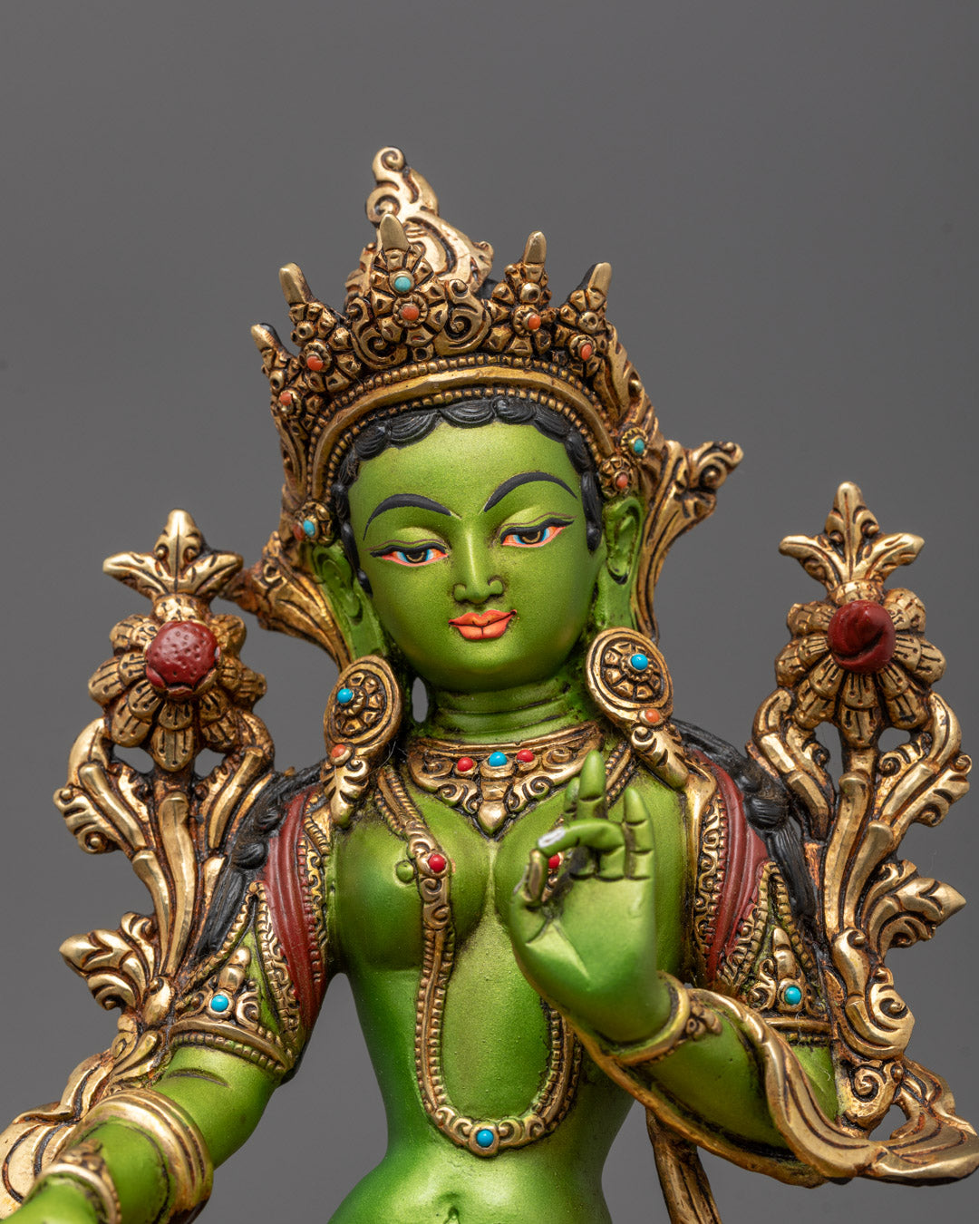 Close-up of Green Tara’s serene face and hands showing detailed craftsmanship