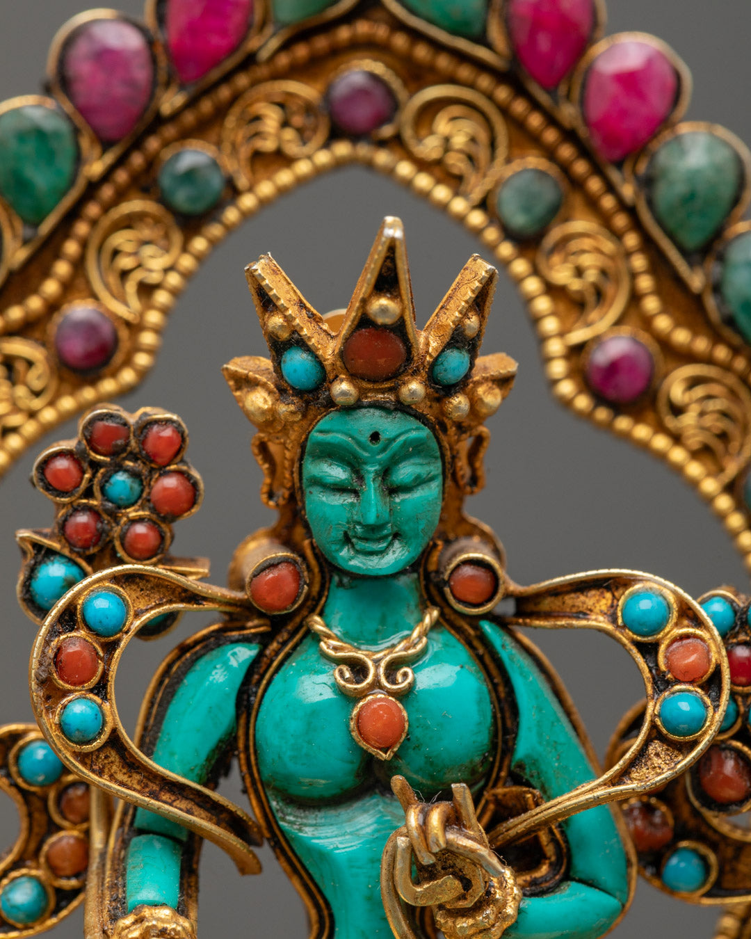 Green Tara’s serene face and jeweled crown featuring five Buddhas, representing divine wisdom and enlightened activity.