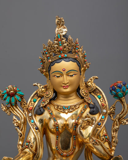 Close-up of Green Tara's serene gold-gilded face and intricate ornamentation
