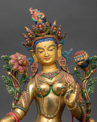 Close-up of Green Tara statue showing delicate utpala flowers and floral garments