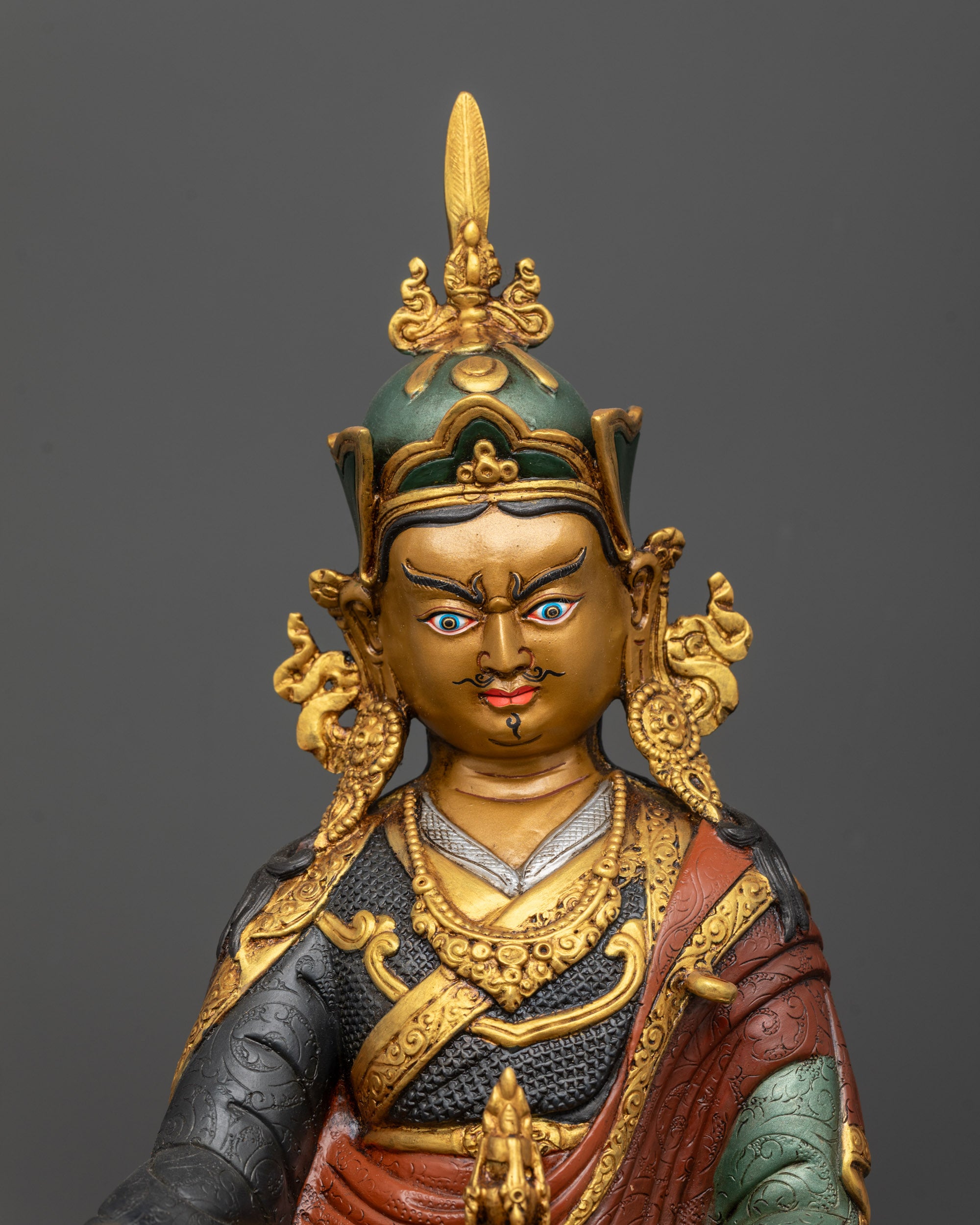 Close-up of Guru Padmasambhava statue showing khatvanga trident and intricate carvings