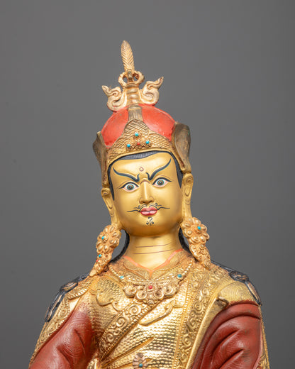 Close-up of Guru Rinpoche face showing intricate detailing and radiant gold-polished
