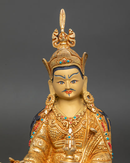 Close-up of Guru Rinpoche face showing serene gold-painted features, radiant 24K gilding, and exquisite Nepalese craftsmanship.