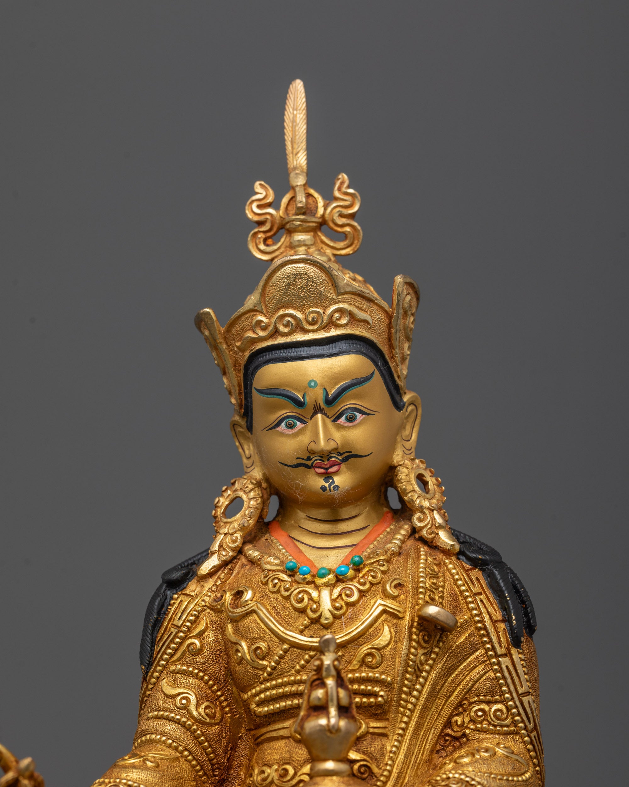 Close-up of Guru Rinpoche's face gilded in 24K gold with peaceful expression