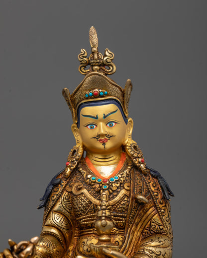 Close-up of Guru Rinpoche's face showing 24K gold gilding and semi-precious crown stones