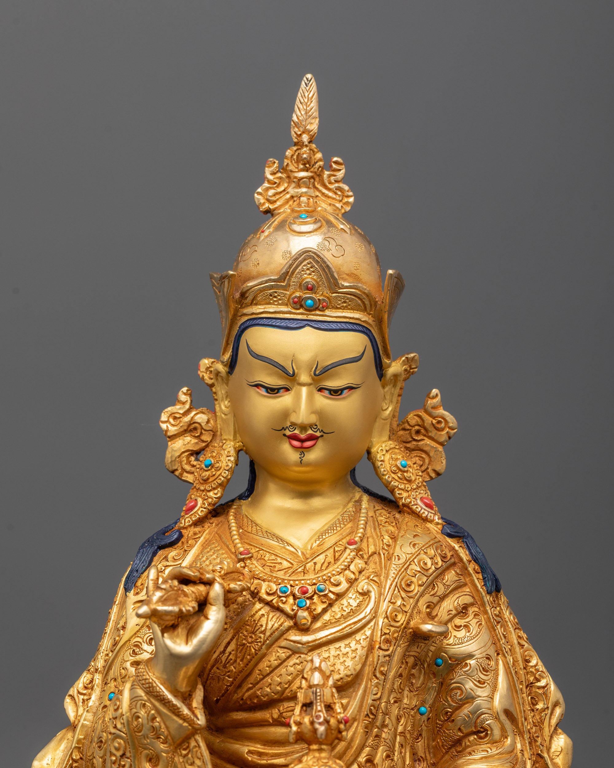 Close-up of Guru Rinpoche’s serene face and intricate crown craftsmanship