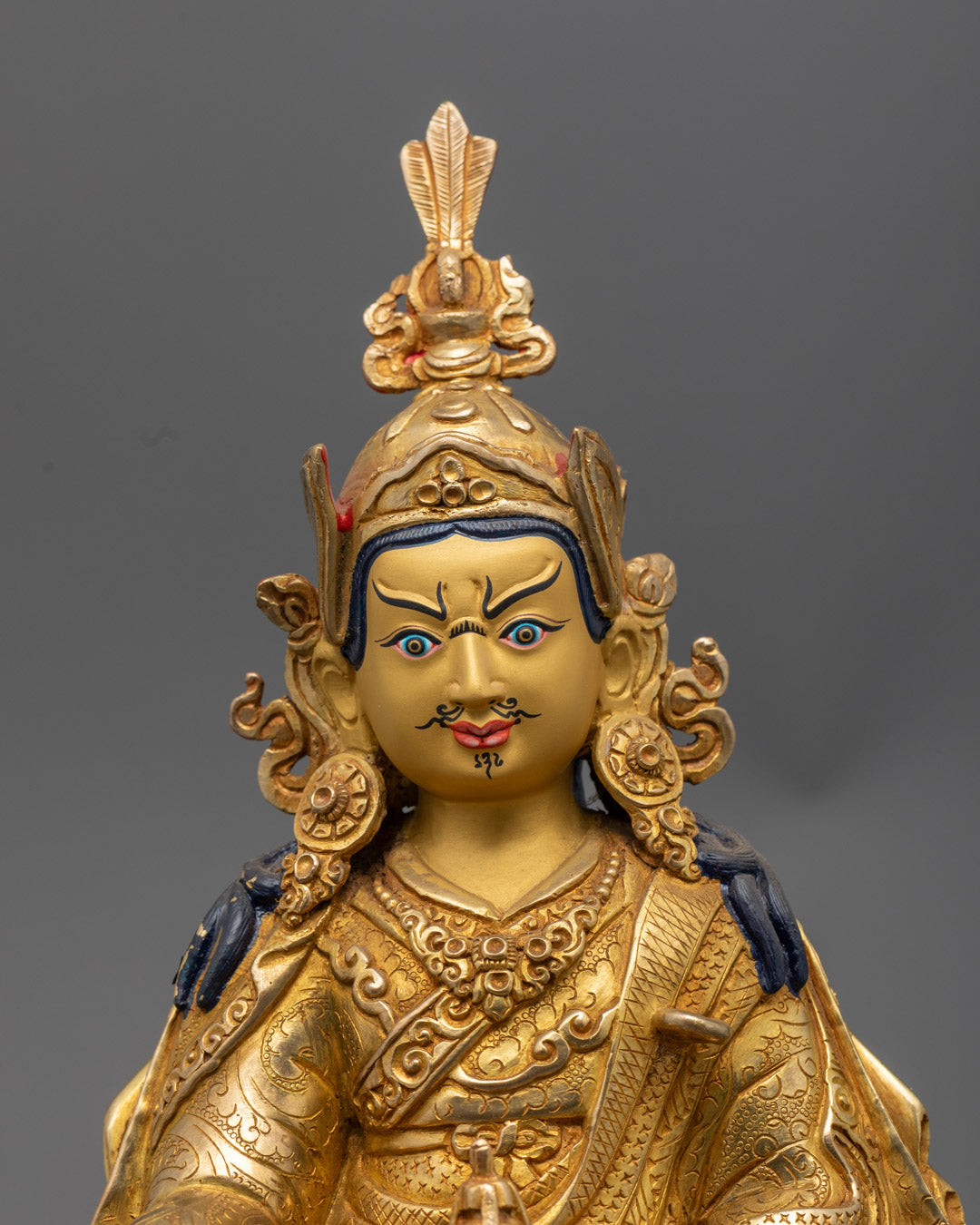 Guru Rinpoche's serene face gilded in pure 24k gold, symbolizing enlightenment and spiritual mastery.