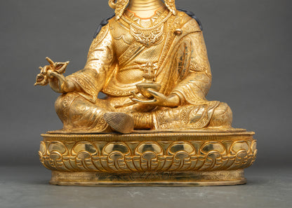 Close-up of Guru Rinpoche statue showing vajra, kapala, and trishula details