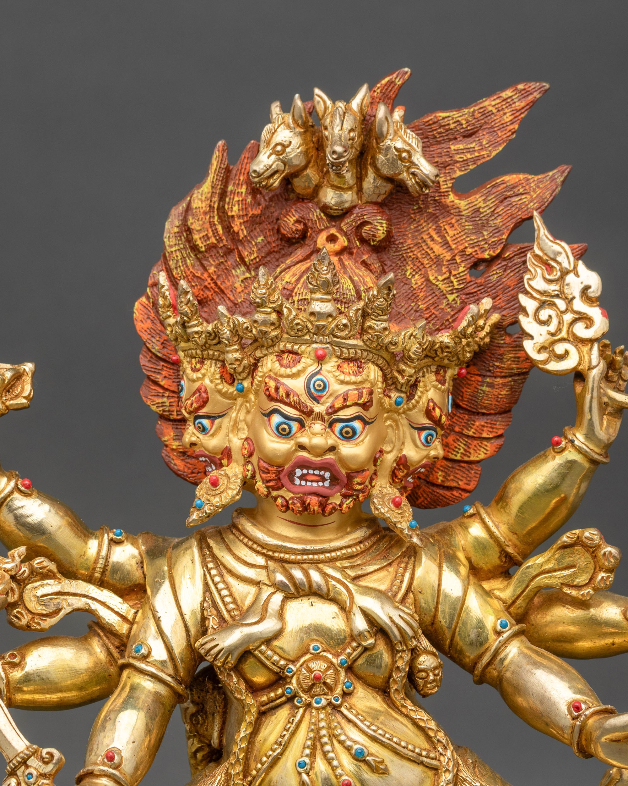 Close-up of Hayagriva statue’s gold-painted face with fierce protective expression
