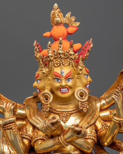 Close-up of Kalachakra’s gold-painted face and sacred implements in hands
