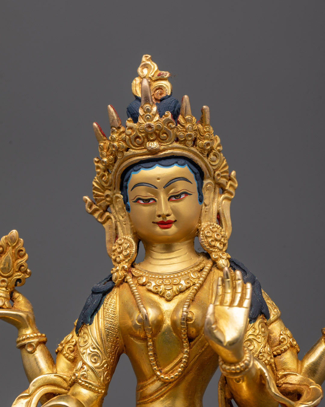 Close-up of Laxmi statue’s intricate crown and facial features in gold gilding